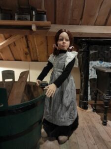 Children's mannequin of a girl with a wash tub at the Goemanszorg museum farm