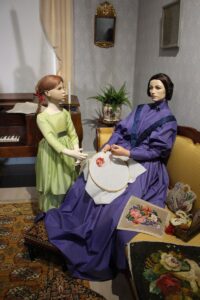 Display mannequin broidering scene in Biedermeier interior at Marela museum